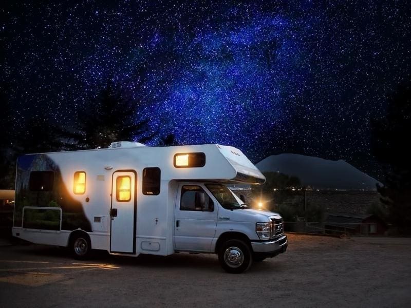 RV parked at night in a starlit sky